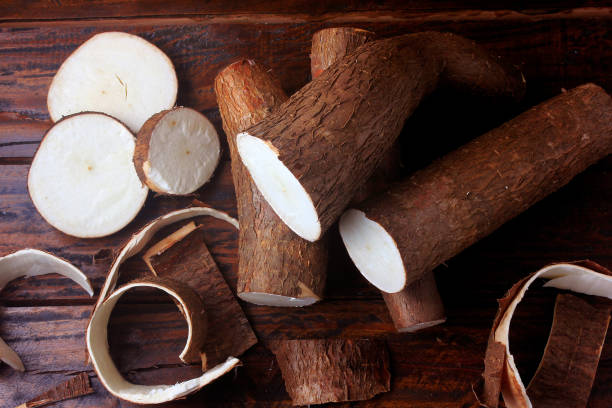 BLOG fresh cassava and peels and slices on rustic wooden table. top view